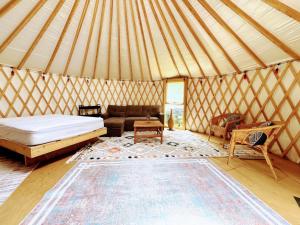 a room with a bed and a couch in a yurt at Sky Nest Glamp-Unplug-Reconnect in Red Bay
