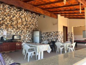 a room with tables and chairs and a kitchen at Chácara a 2km do centro de São Thomé in São Thomé das Letras