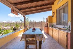 an outdoor kitchen with a blue table and chairs at Eco del Mare in Pachino