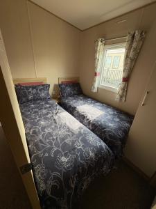 a small bedroom with a bed and a window at Summer breeze in Lossiemouth