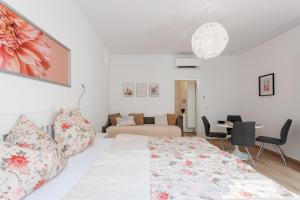 ein weißes Schlafzimmer mit einem Bett und ein Wohnzimmer in der Unterkunft Central Renovated Apartment with AC & Free Parking in Wien