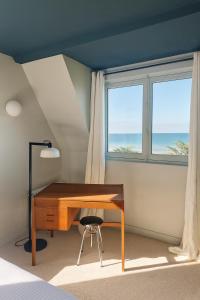a bedroom with a desk and a window at La Sauvagère - Villa Art Deco face à Omaha Beach in Vierville-sur-Mer +84 photos
