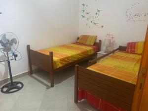 a bedroom with two beds and a fan on the wall at Elhafi in Oujda