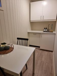 Central apartment في ترومسو: مطبخ مع طاولة بيضاء وكاونتر