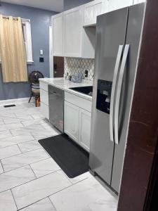 a kitchen with a refrigerator and a tile floor at Historic Retreat in Detroit +10 photos