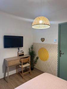 a bedroom with a desk and a tv and a bed at Etoile du Matin avec Piscine Zen Privative in Margon