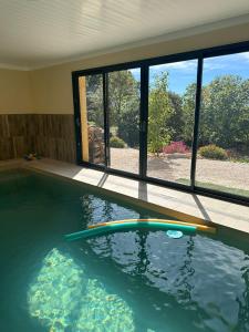 a swimming pool with a large window in a house at Etoile du Matin avec Piscine Zen Privative in Margon +3 photos