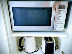 a microwave on a shelf with a coffee maker and a blender at Biliaba in Rhodes Town +8 photos