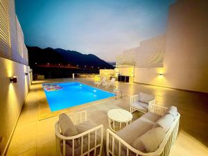 a living room with a swimming pool and chairs at Lux 3BR Villa, Sea Views & Pool in Sharm