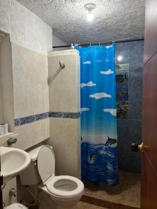 ein Badezimmer mit Toilette und Duschvorhang in der Unterkunft Hospedaje Casa Taganga in Taganga + 14 Fotos