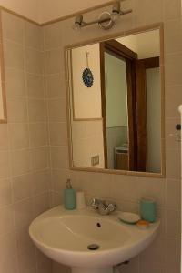 uma casa de banho com um lavatório e um espelho em Il Gelso 'd la Costa em Lesegno