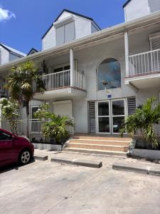 a house with a red car parked in front of it at Grand Case Beachfront Apartment, Perfect for a couple looking a romantic Gateway in Grand Case