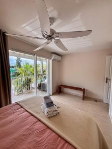 a bedroom with a bed with a ceiling fan at Grand Case Beachfront Apartment, Perfect for a couple looking a romantic Gateway in Grand Case