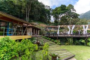 a building with a porch and stairs to a house at Pousada Paraíso Açú in Itaipava