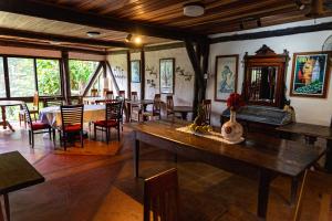a dining room with a large wooden table and chairs at Pousada Paraíso Açú in Itaipava