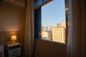 una camera da letto con finestra affacciata sulla città di 360 Centro Metrô Uruguaiana By SUHCasa a Rio de Janeiro