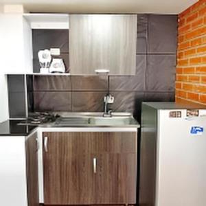 a kitchen with a sink and a refrigerator at Apartaestudio cerca al mar - Disfruta santa marta in Gaira