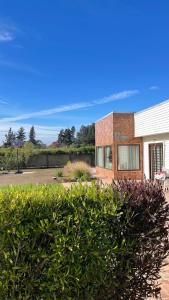 a brick house with a bush in front of it at Parcela de agrado en Rocas de santo domingo in Santo Domingo