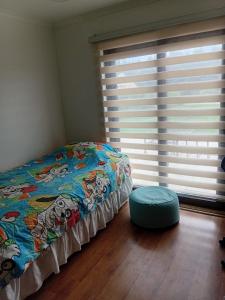 a bedroom with a bed and a large window at Parcela de agrado en Rocas de santo domingo in Santo Domingo