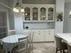 a kitchen with white cabinets and a table and chairs at Spacious King Suite Home With Serene Patio in Hattiesburg