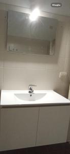een witte wastafel in een badkamer met een spiegel bij A casa di A in Milaan