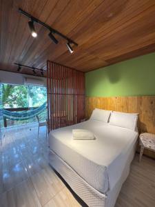 Un dormitorio con una cama blanca y una pared verde. en Pituba Vile - Apartamento Jardim, en Itacaré 12 fotos más