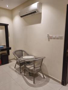 Habitación con mesa, 2 sillas y ventilador. en راحتي هنا 7, en Riad