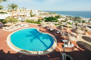 einen Blick über einen Pool mit Sonnenschirmen und das Meer in der Unterkunft Stanza Luna, Domina Coral Bay, Prestige hotel in Sharm El Sheikh