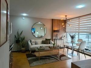 a living room with a couch and a table and a mirror at Apartment - 2Bedrooms - QueenBed - Balcony - Parking - 7thFLOOR in Quito