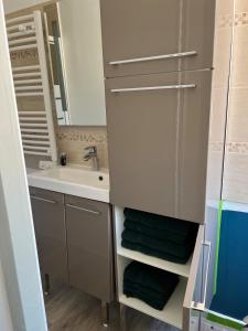 a small bathroom with a sink and a mirror at Petite maison rose in Le Havre +16 photos