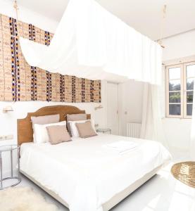 a white bedroom with a large bed with white sheets at Quinta de Sá in Vila Nova de Gaia