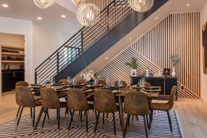 a dining room with a table and chairs and a staircase at Downtown Luxury Villa Hot Tub Walk To Lake in Coeur d'Alene