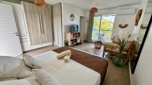 a bedroom with a large bed and a living room at L'Escale - vue mer avec cuve in Saint-François
