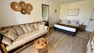 a living room with a couch and a bed at L'Escale - vue mer avec cuve in Saint-François +11 photos