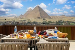 a table with food and drinks and the pyramids at Crowne Pyramids View inn in Cairo