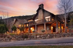 a large log home with a wrap around porch at Luxe Artful Mountain Retreat with 4 King Suites, 8 Person Hot Tub and 3 Decks in Carbondale