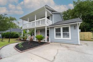 a white house with a porch and a driveway at Coastal Haven 5 mins to Beach 15 mins to dtwn in Charleston