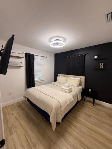 1 dormitorio con 1 cama con pared negra en Coastal Comfort 2BR Getaway St Pete, en San Petersburgo
