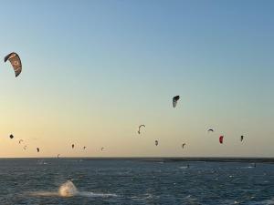 a group of kites flying in the sky over the water at Le rêve des kitesurfeurs in Itarema