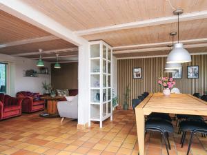 a living room with a table and a dining room at 4 star holiday home in Henne in Henne