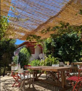 a patio with a table and chairs and an umbrella at Quinta da Maínha - Charming Houses - Escape to Nature in Braga +69 photos