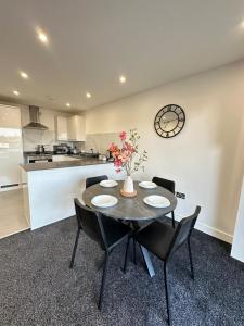 a dining room with a table and chairs and a clock at Bright & Spacious Apartment with large balcony and free parking in Oxford