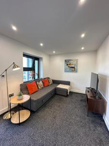 a living room with a couch and a television at Bright & Spacious Apartment with large balcony and free parking in Oxford