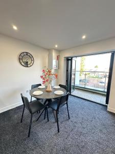 a dining room with a table and chairs and a large window at Bright & Spacious Apartment with large balcony and free parking in Oxford +17 photos