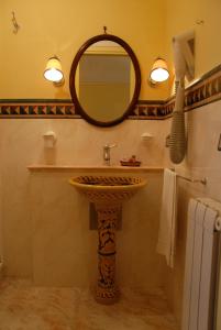 Hotel Villa Palocla في شاكا: حمام مع حوض ومرآة