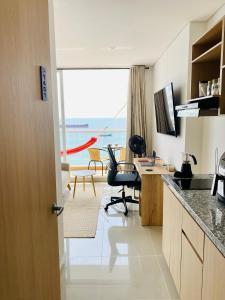 a kitchen with a desk and a view of the ocean at "Blue loft Oceanview Minimalist Studio in Marina Rooftop Pool Prime Location" in Santa Marta +32 photos