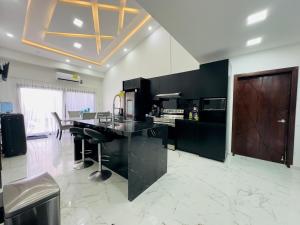 a kitchen with black counters and a table and chairs at Casa Arboleda Tu paraíso privado en Danli in Danlí