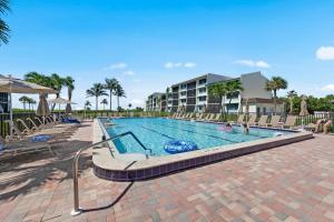 Una piscina en un resort con gente en ella. en Island Retreat Loggerhead Cay 443, en Sanibel