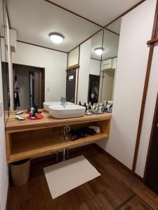 a bathroom with a sink and a large mirror at My Chalet Hakuba in Hakuba +15 photos