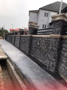 a stone wall with snow on it in front of a house at International royal hotel in Owerri +19 photos